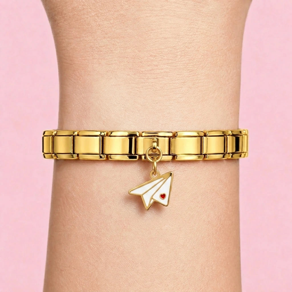 Paper plane dangle charm worn on a gold Italian bracelet
