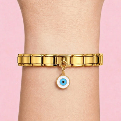 Blue evil eye dangle charm worn on a gold Italian bracelet