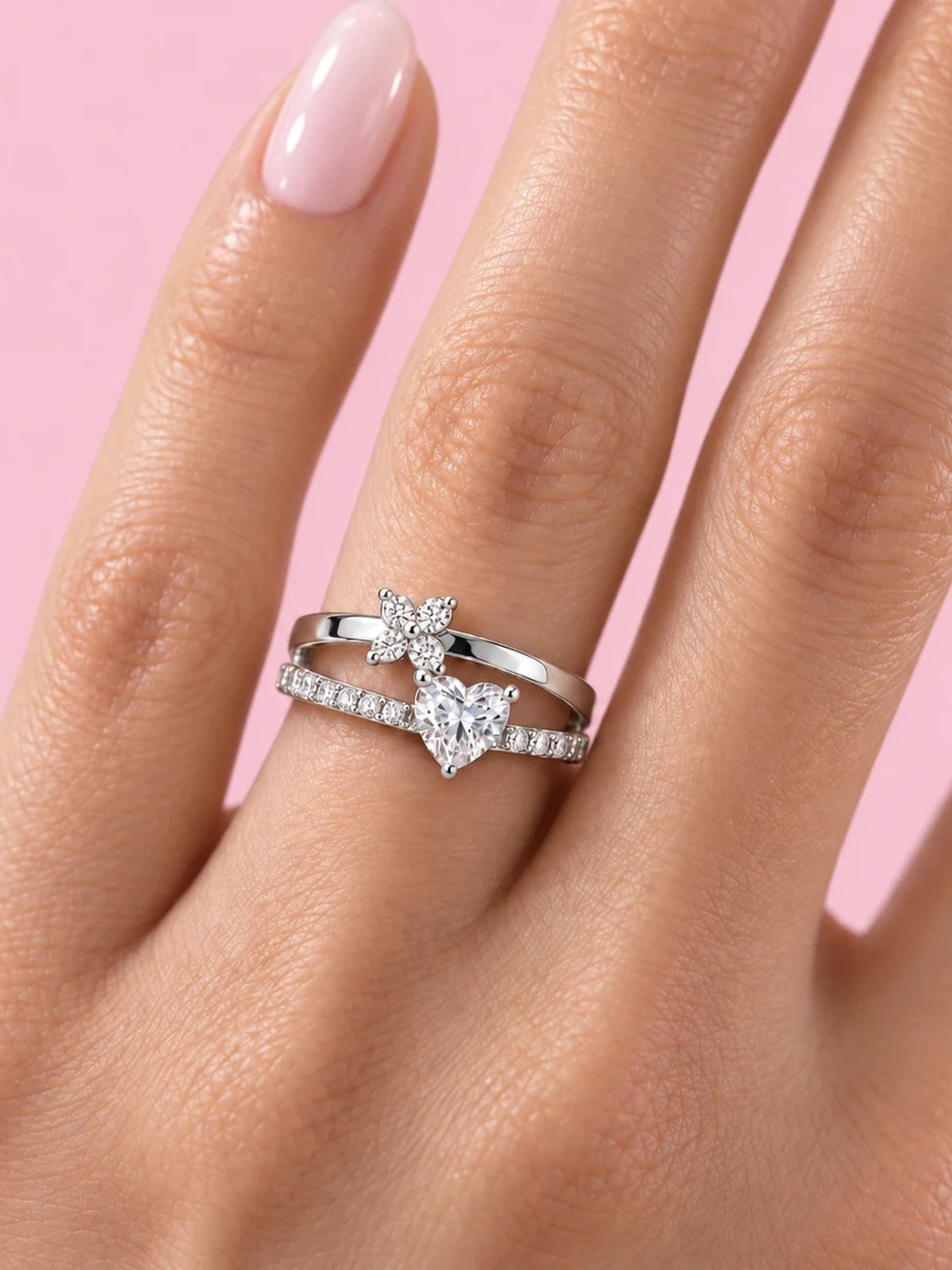 CHIARO Fiore ring worn on a hand, pink background