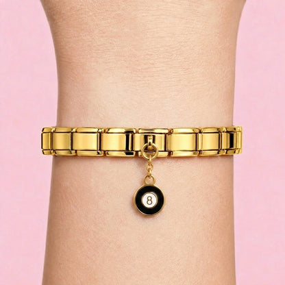 Eight ball dangle charm worn on a gold Italian bracelet