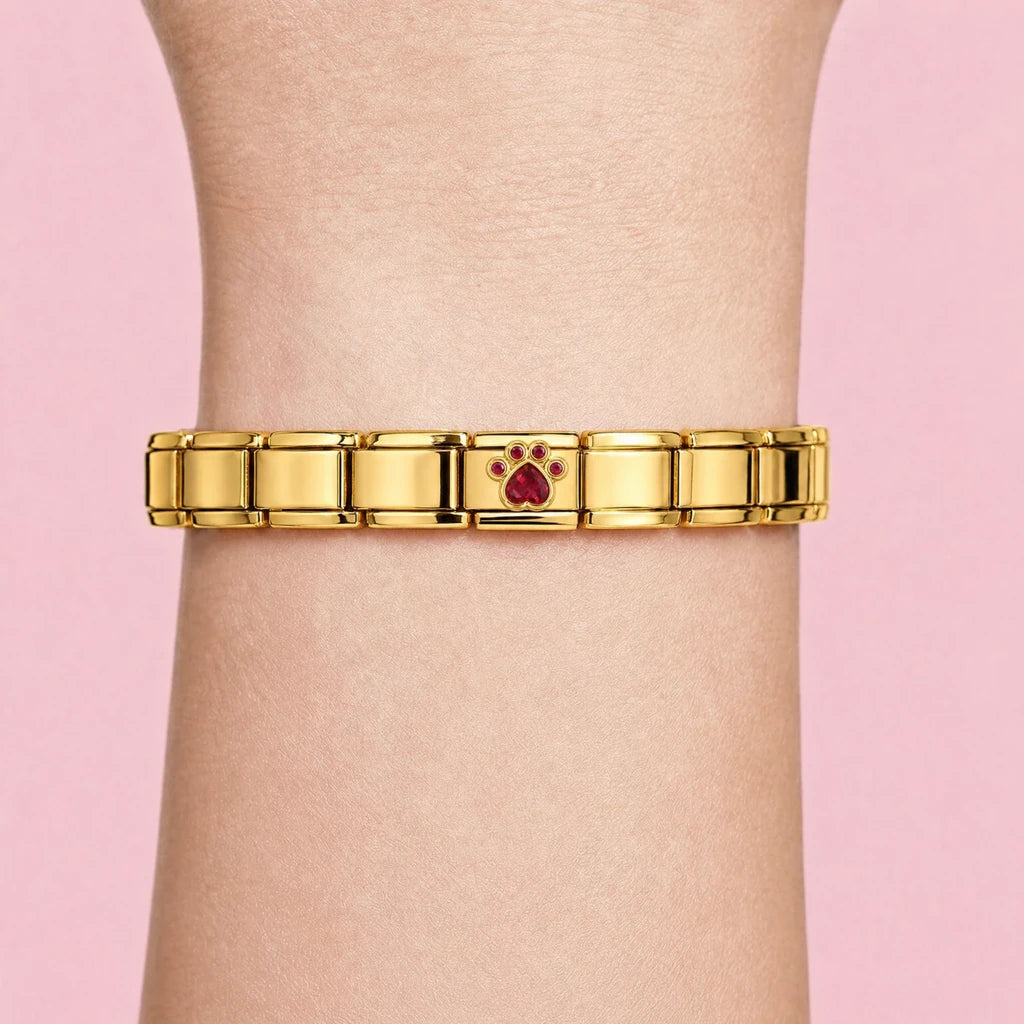 Ruby Paw charm worn on a gold Italian bracelet