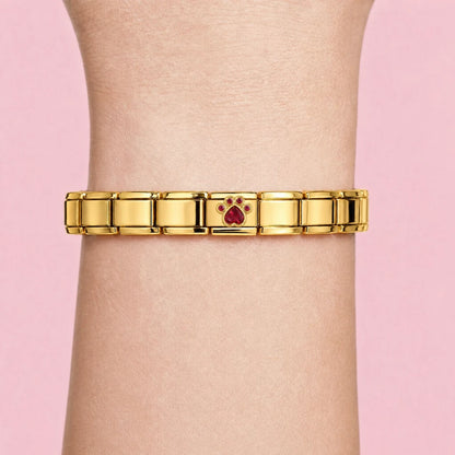 Ruby Paw charm worn on a gold Italian bracelet