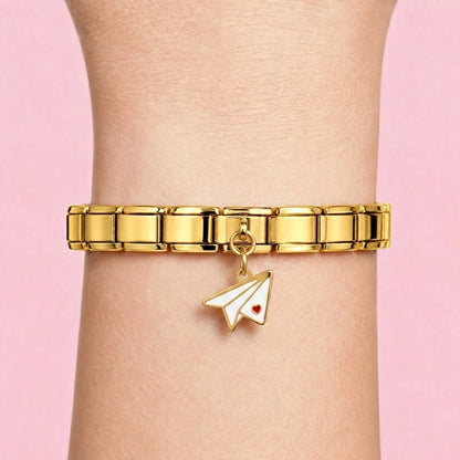 Paper plane dangle charm worn on a gold Italian bracelet