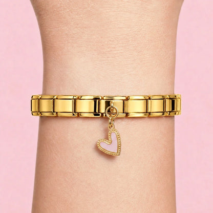 Pink heart dangle charm worn on a gold Italian bracelet