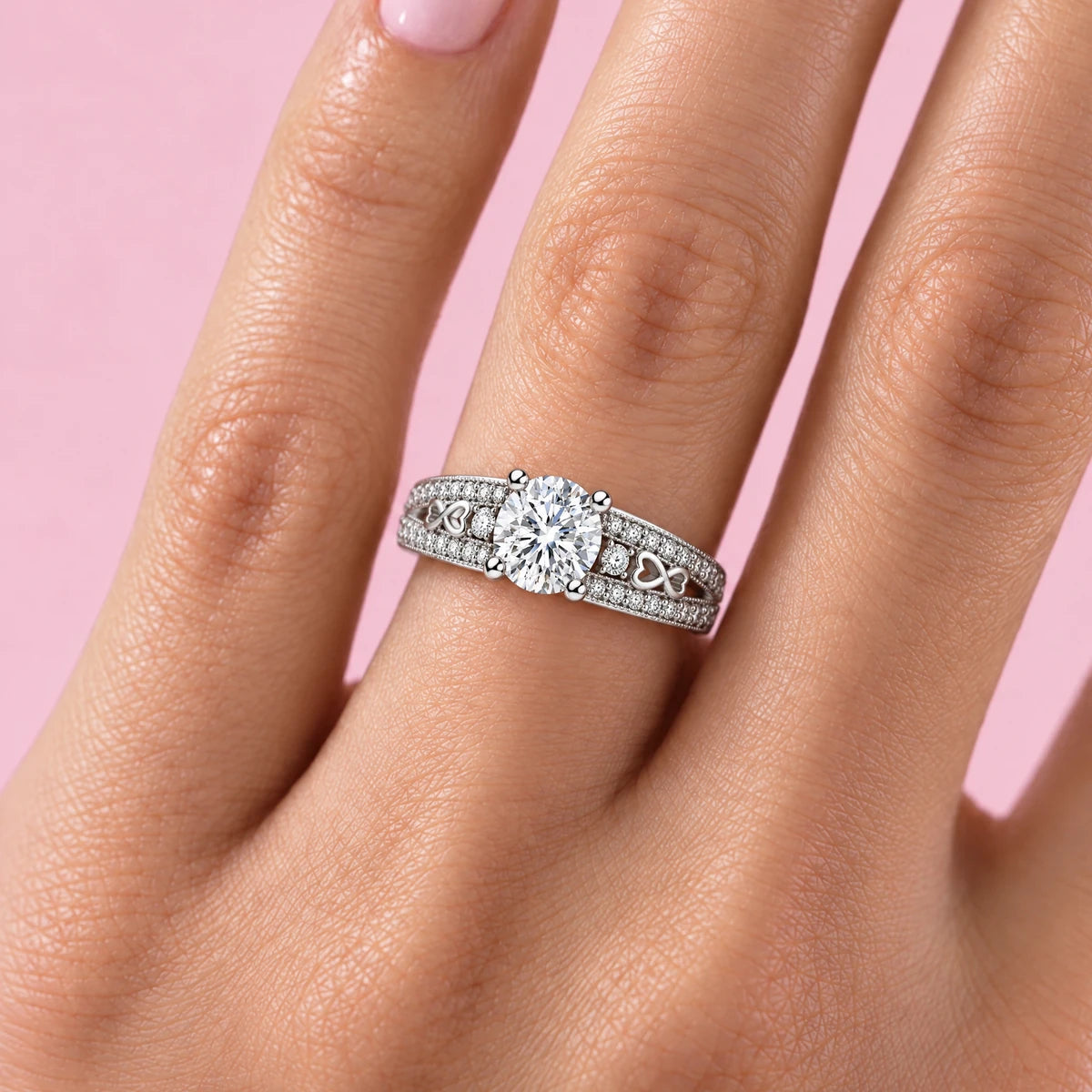 Dolce hearts pave moissanite ring worn on the ring finger, pink background