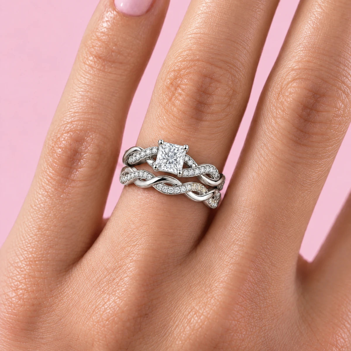 Eterna princess bridal set worn stacked on the ring finger, pink background