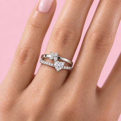 Fiore heart and flower moissanite ring worn on the ring finger, pink background