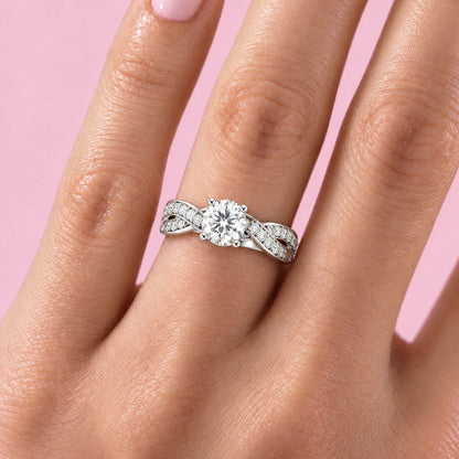 Intreccio twist pave moissanite ring worn on the ring finger, pink background
