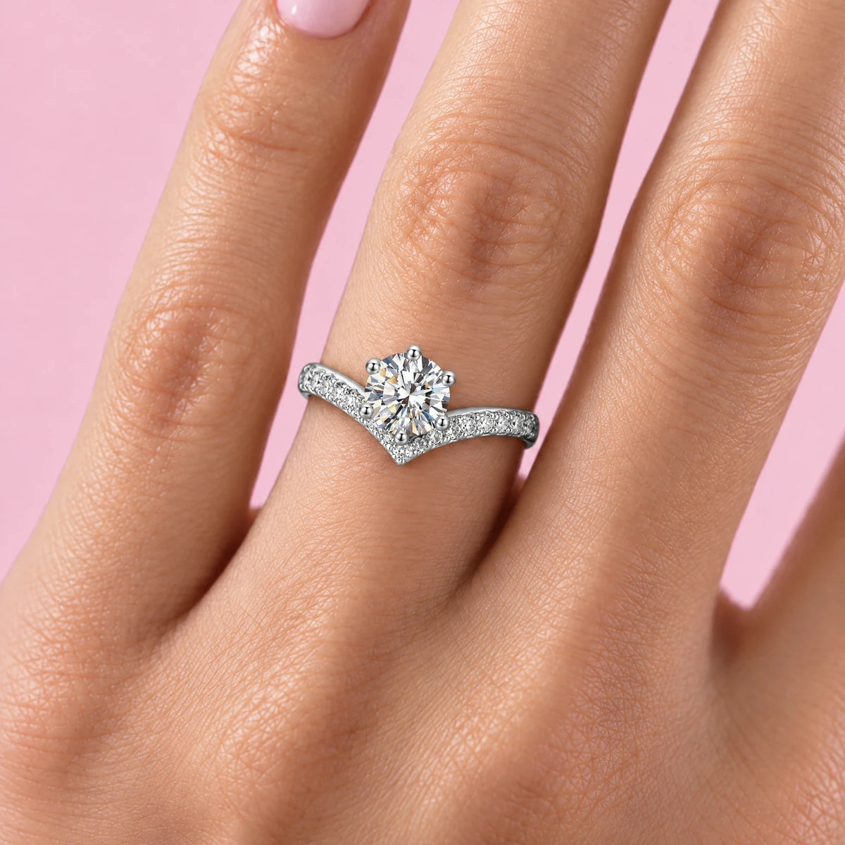 Vetta chevron moissanite ring worn on the ring finger, pink background
